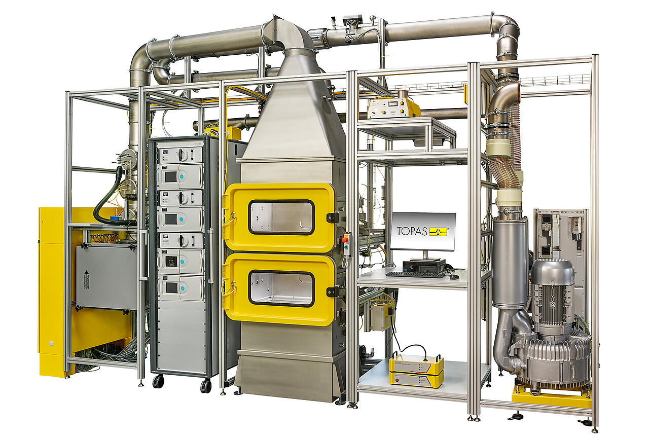 Frontalansicht FCT 113 für Prüfung von Ansaugluftfiltern, geöffnetes gelbes Fenster, Schriftzug oben rechts "Coming Soon"