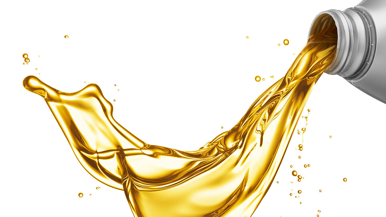 Gelbes Motoröl kommt im Schwall aus grauer Flasche